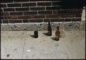 View of four bottles on the ground