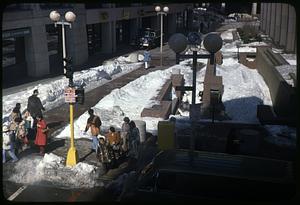 People walking by snow covered Boston City Hall Plaza