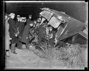 Spectators and police surround an wrecked airplane