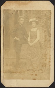 Young man and woman standing in front of house