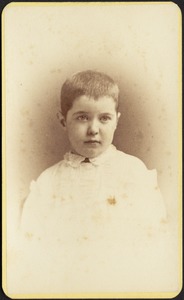 Young child with shorn hair, white top
