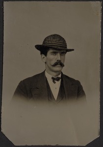Gentleman in dark suit with handlebar mustache and black straw hat
