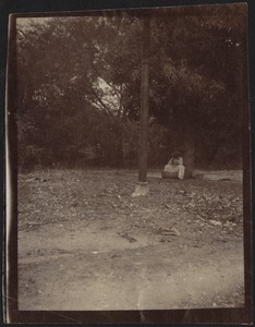Woman in white dress sitting on ground with large basket