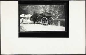 Unidentified man standing in front of horse-drawn carriage in snow; possibly Helen Stevens Coolidge with hat seated in back