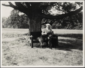 Ashdale Farm. John Gardner Coolidge seated on bench under tree holding large dog.