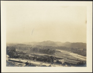 View of park with benches overlooking railroad; mountains in distance