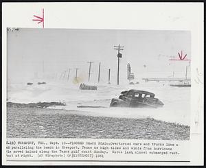 Flooded Beach Road--Overturned cars and trucks line a road paralleling the beach in Freeport, Texas as high tides and winds from hurricane Carla moved inland along the Texas gulf coast Sunday. Waves lash almost submerged restaurant at right.