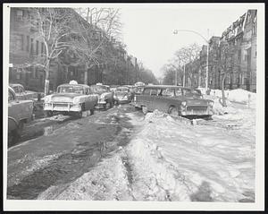Like Narrow Country Road, this is Beacon street, Back Bay, near Massachusetts avenue. Snow, ruts and indiscriminately parked cars have reduced principal thoroughfare to a single traffic lane. Its condition was a contribution factor to a major traffic jam in the Kenmore square area yesterday afternoon.