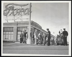 Auto workers on strike in front of a Ford building