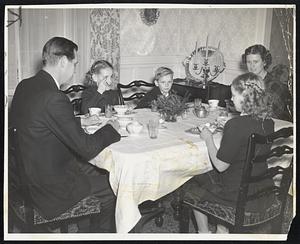 At Home With the Tobins-Breakfast today was an oft-interrupted meal for Gov. Maurice Tobin and his family, although they all did justice to the substantial servings prepared while they were at Mass by Mass Sullivan, who has served them as cook, maid and nurse for nealy seven years. Photo (upper) was snapped in one of few moments all were at table. Miss Maurice was especially proud of a gold watch, on a chain which belonged to his grandfather, given him by his father today as an inaugural present. Here (lower) he shows it to his sisters, Helen Louise, 11; Carol Ann, 10, for umpteenth time.