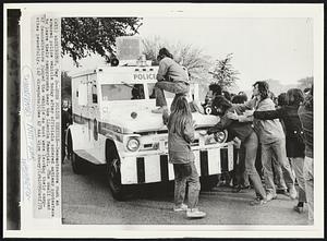 Rush Police Vehilce--Demonstrators rush an armored police vehicle today after officials ordered antiwar protesters to leave their campground near the Lincoln Memorial. (The small band of demonstrators jumped the vehicle as most were leaving their campsites peacefully.