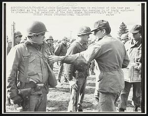 Ohio National Guardsman is relieved of his tear gas cannister as the troops were called to ranks for turning in of their equipment in preparation for vacating of the Kent State University,5/6 and 5/7.