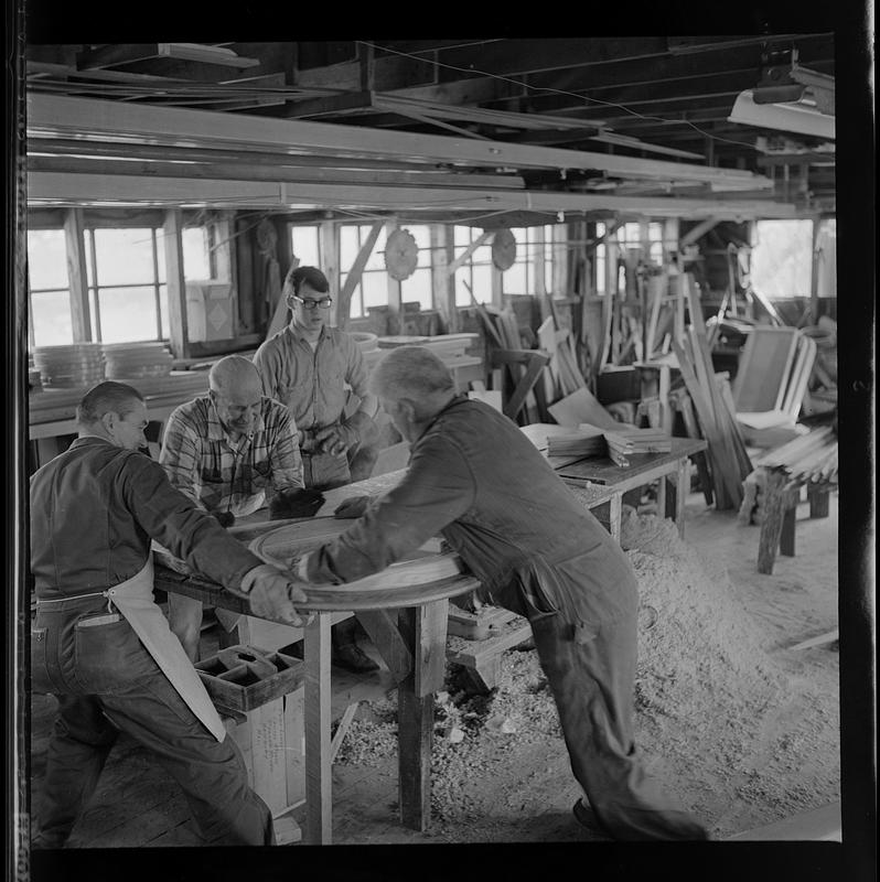 Pert Lowell, right, and others working in boat shop