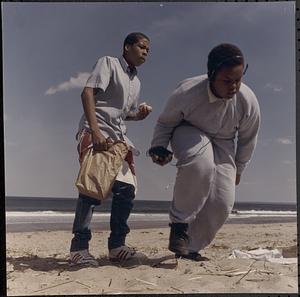 Two boys on the beach, Jamie listening to a portable cassette player and his friend eating a sandwich