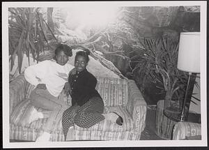 Two young women posing on a couch