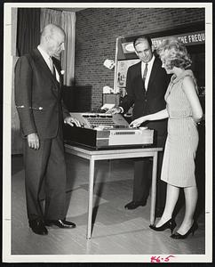 Chairman of the board of Raytheon Company, and Thomas L. Phillips, president, watch demonstration by employe Lyn Lester of Edex Corporation's control console for classroom. The Lexington based electronics firm announced at the annual meeting yesterday it plans to acquire the company.