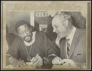 Boston: Boston Celtics 'General Manager Arnold "Red" Auerbach (R) locks on as player-coach Bill Russell signs a two-year contract for an estimated 400-thousand dollars here (9/23). Russell is wearing a dashiki new breed suit with a peace medallion around his neck.