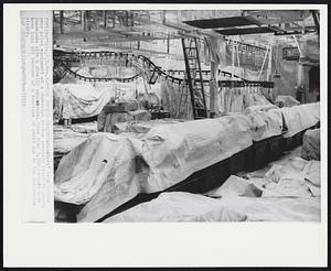 Steel Strike Spectre-Painters' drop cloths over idled equipment at a Chevrolet engine assembly plant in nearby Tonawanda give a ghostly appearance. More than 3,000 workers have been laid off because of a shortage of steel due to the nationwide strike.