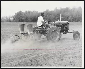 Plating In Dust Bowl -- Frank Whittemore, of Hollis, N.H.; plants beans with the dust kicked up behind the tractor, another sign of the area's drought. Farmers say that May, the month [illegible]ing most vegetables, is about twice as [illegible] year at this time.