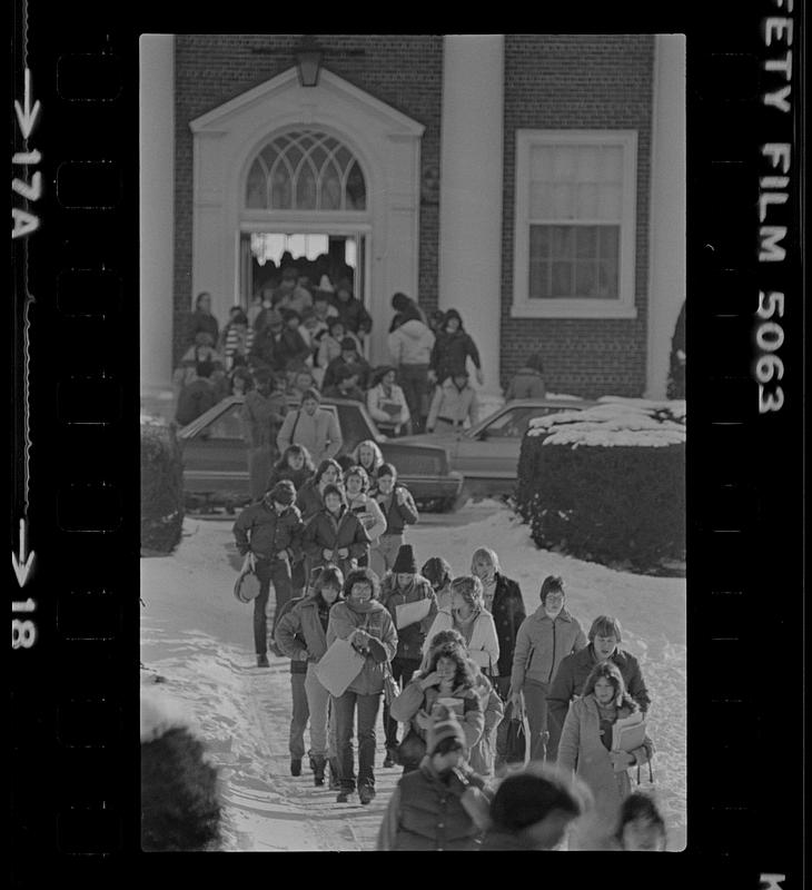 Students walking on snowy sidewalk