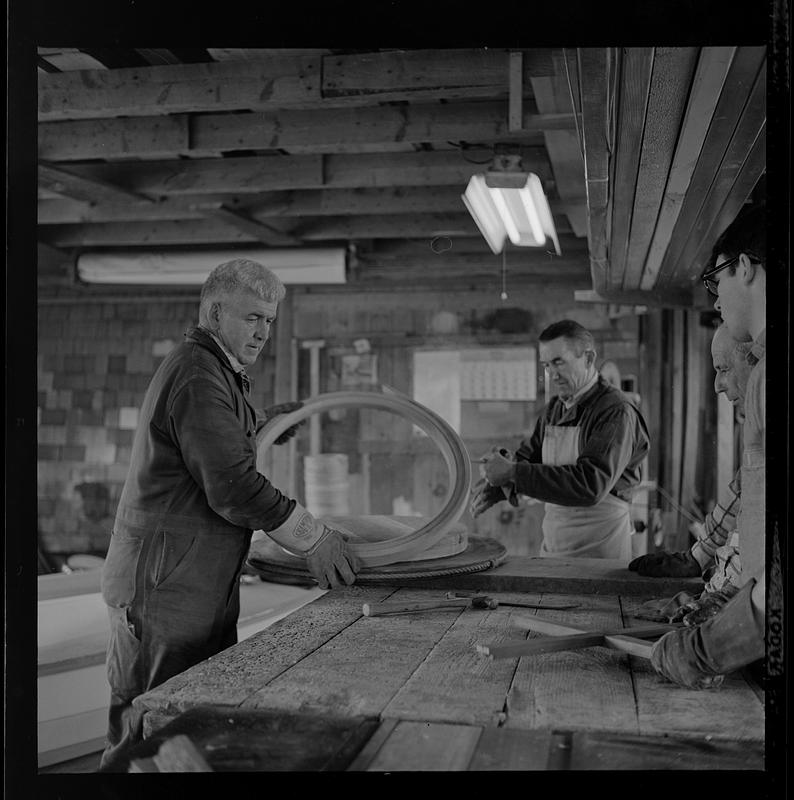 Pert Lowell and others working in boat shop