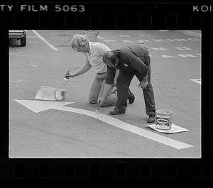 Workmen paint traffic direction arrow, Boston