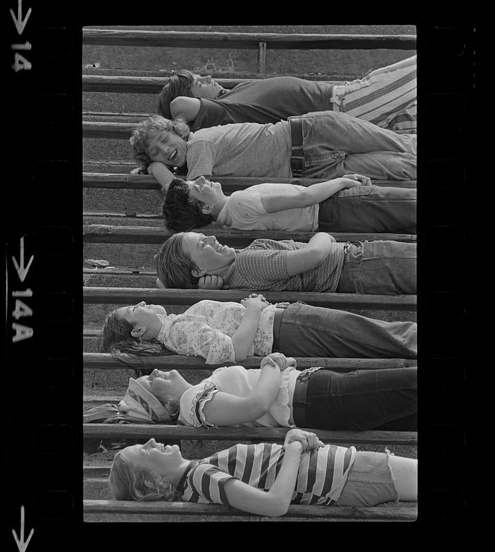 School kids relax on bleachers in summer sun, Dorchester