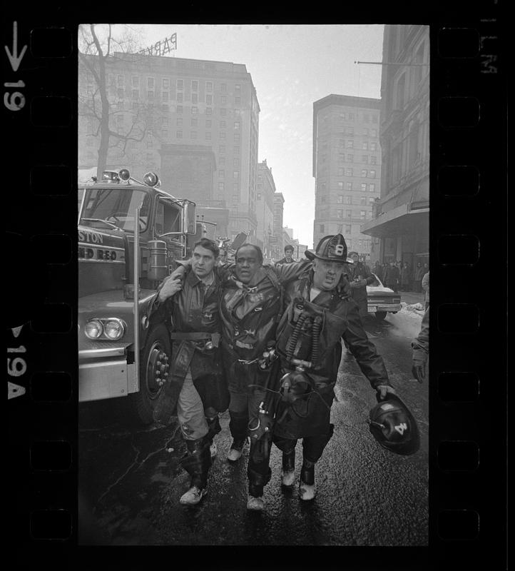 Companions aid injured fireman, Tremont Street, Boston