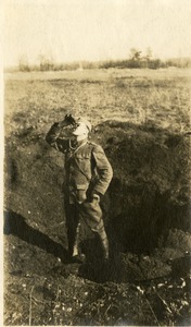 Soldier standing in blast crater, ca. 1918