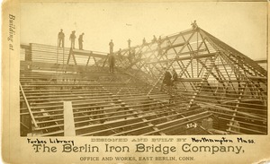 Laborers from the Berlin Iron Bridge Company at work on building the roof of the Forbes Library