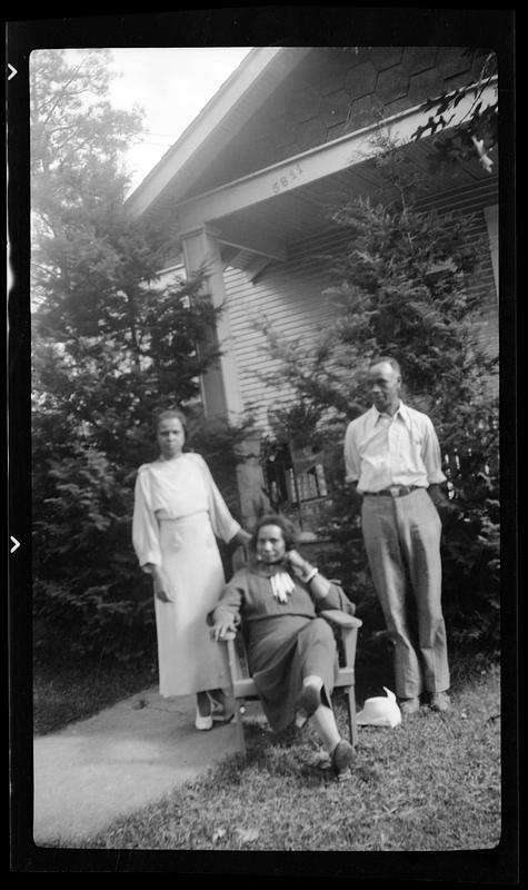 Two women and a man, one woman seated