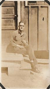 U.S. Marine identified elsewhere as "Dick" smoking a cigarette, seated on steps at U.S. Marine base Quantico, VA