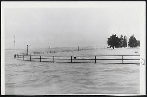 Potomac Takes Over Recreation Area- Rain-swelled waters of the Potomac River wash over the East Potomac Park area at Hains Point in Washington, leaving only the iron guard rail visible. A tourist road runs inside the railing and in foreground, back of the railing, is a golf course. The river went over the seawall earlier in the day.