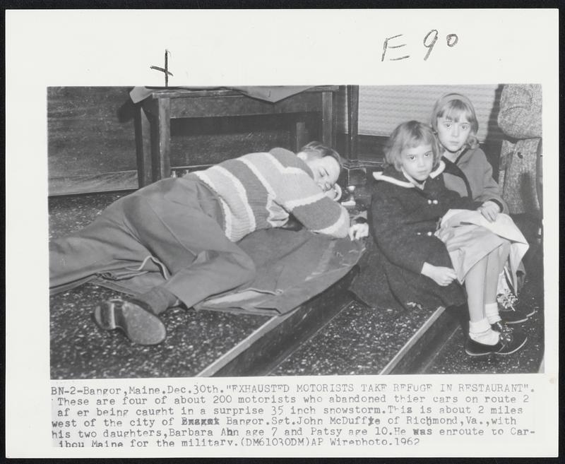 Bangor, Maine. "Exhausted Motorists Take Refuge In Restaurant". These are four of about 200 motorists who abandoned their cars on route 2 after being caught in a surprise 35 inch snowstorm. This is about 2 miles west of the city of Bangor. Sgt. John McDuffe of Richmond, Va., with his two daughters, Barbara Ann age 7 and Patsy age 10. He was enroute to Caribou Maine for the military.