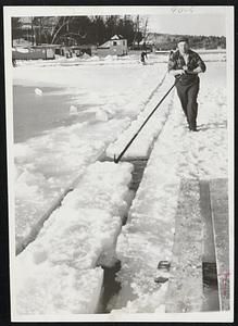 Jockeying Ice Blocks is Normal Colby of Wendell, N. H. Colby is a mill worker by trade but devotes two days a year to the ice harvest.