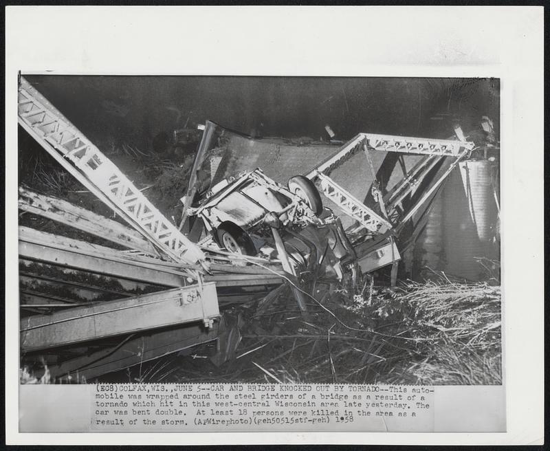 Car and Bridge Knocked Out by Tornado--This automobile was wrapped around the steel girders of a bridge as a result of a tornado which hit in this west-central Wisconsin area late yesterday. The car was bent double. At least 18 persons were killed in the area as a result of the storm.