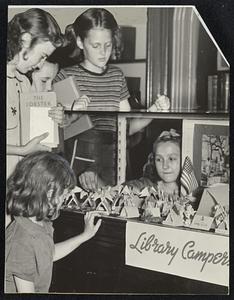 Bottom, tenting on the library camp ground at the South Boston branch. Dorothy Stravinsky adds a flag to her tent as credit for having read another book in the summer course.