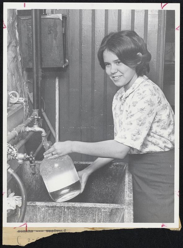 CD Begins at Home--Rotating food and water supplies is important in maintaining an effective CD home shelter. Here Jean Woodward, daughter of CD official, replenishes water cache