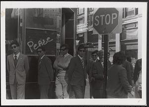Group of men on the corner of Harrison and Beach Streets in Chinatown, Boston