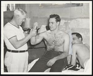 Take Good Care of That Arm- Doc May, Bees trainer, casts an approving eye at the stout right arm of Sebby Sisti, third sacker, following a workout at San Antonio.