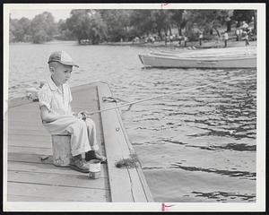 Study in Concentration is 5-year-old Stephen Kent as he tries his luck in the Boston Traveler-Boston Park Department Fishing Rodeo. Swarms of youngsters covered the banks of Jamaica Pond for the annual event. Stephen is son of Mr. and Mrs. Norma Kent of 11A Myrtle St., Jamaica Plain.