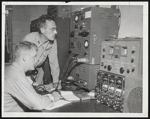 Nerve Center- M/Sgt. Neal Taffe of Boston and Capt. Kenneth A. Smith open up emergency statewide communications hookup at National Guard Armory, Commonwealth avenue, to help co-ordinate the Guard's disaster relief operation.