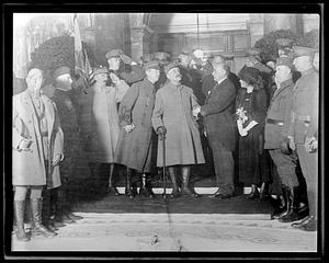 Ferdinand Foch shakes hands with an unidentified man in the center of a group of people