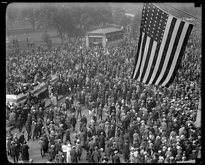 A crowd gathering on Tremont Street, a flag in foreground