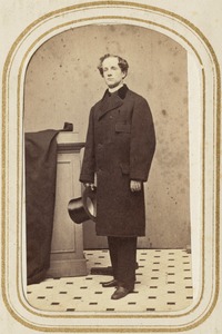 Portrait of a man standing holding a top hat