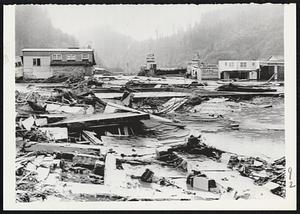 Destruction of downtown Klamath is shown in view from main thoroughfare of Highway 101. Helicopters are operating mercy missions in the area where many persons are short of food.