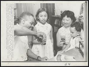 Little Things Mean a Lot-- Korean War turncoat Clarence Adams introduces his family to one of the joys of life in America after his return to his hometown today. Adams is serving cola to his daughter, Della, 7, his wife, Lui, and son, Louis, 3. Adams chose to go to China at the close of the war. He was a corporal in the U.S. Army when he was captured in Korea.