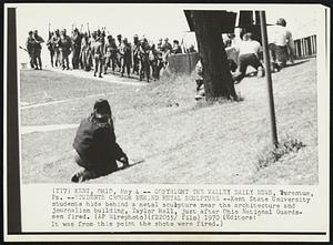 Students Crouch Behind Metal Sculpture --Kent State University students hide behind a metal sculpture near the architecture and journalism building, Taylor Hall, just after Ohio Nationals Guardsmen fired. (Editors: It was from this points the shots were fired.)