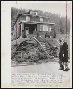 "Walking" Hill Rests- Geology Prof. Charles R. Fettke of Carnegie Tech gestures with hammer at causes of earth slide wrecking eight-room house. Dr. Fettke said hill may resume slide. Kay Badollet, Tech employee, is listening.