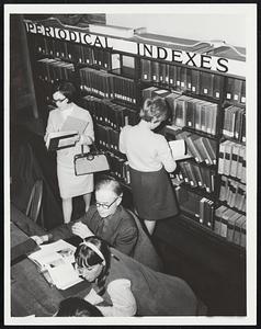 Surrounded by Students-In the periodical room a library patron reads in the midst of student traffic.